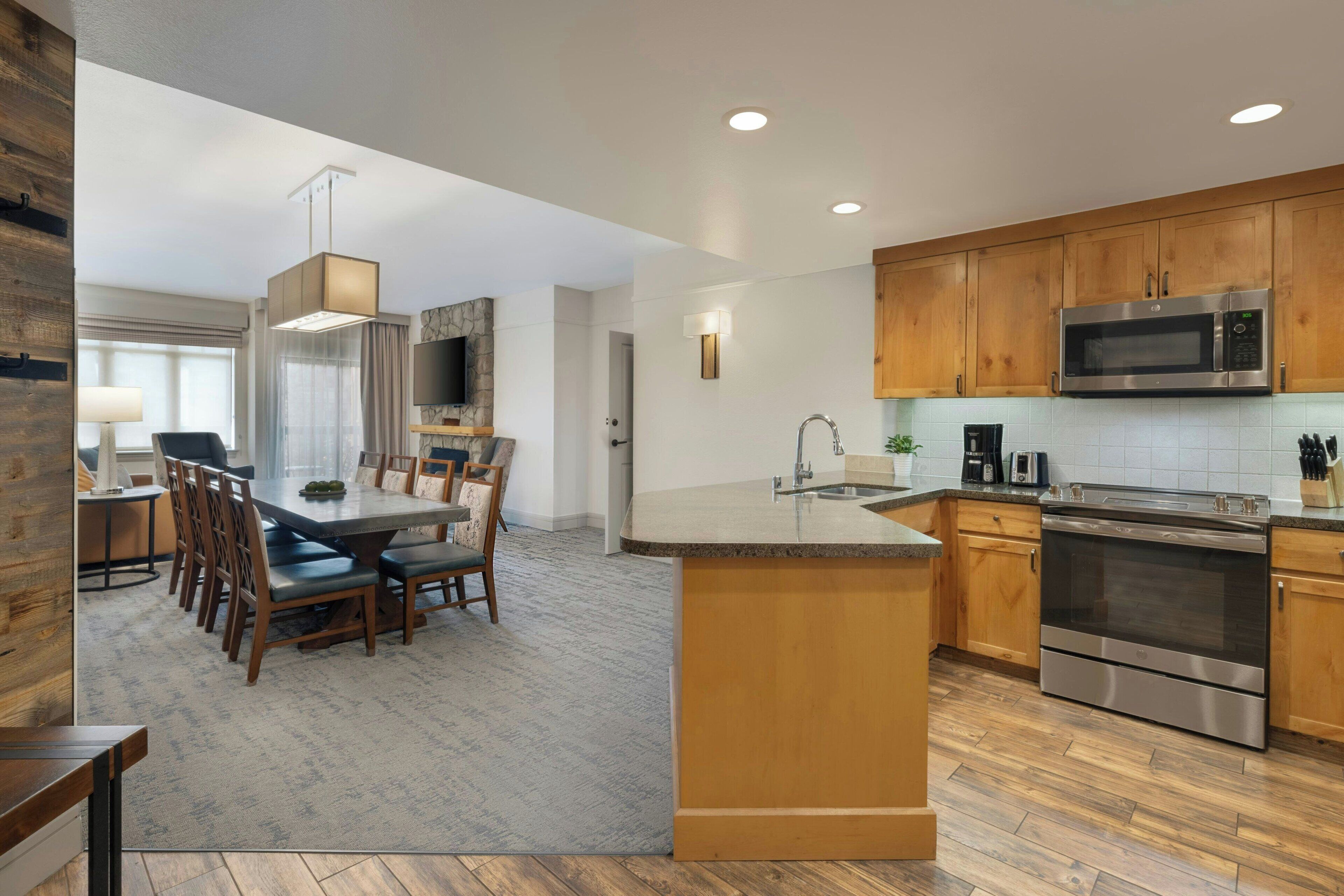 A modern kitchen with wooden cabinets, stainless steel appliances, and a central island.