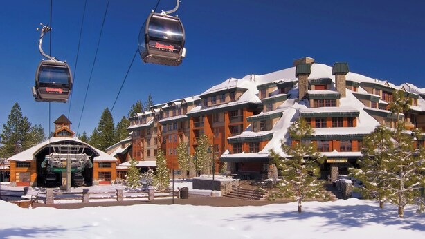 A ski resort building with multiple floors, a ski lift, and snow-covered surroundings. - Marriott's Timber Lodge (South Lake Tahoe)