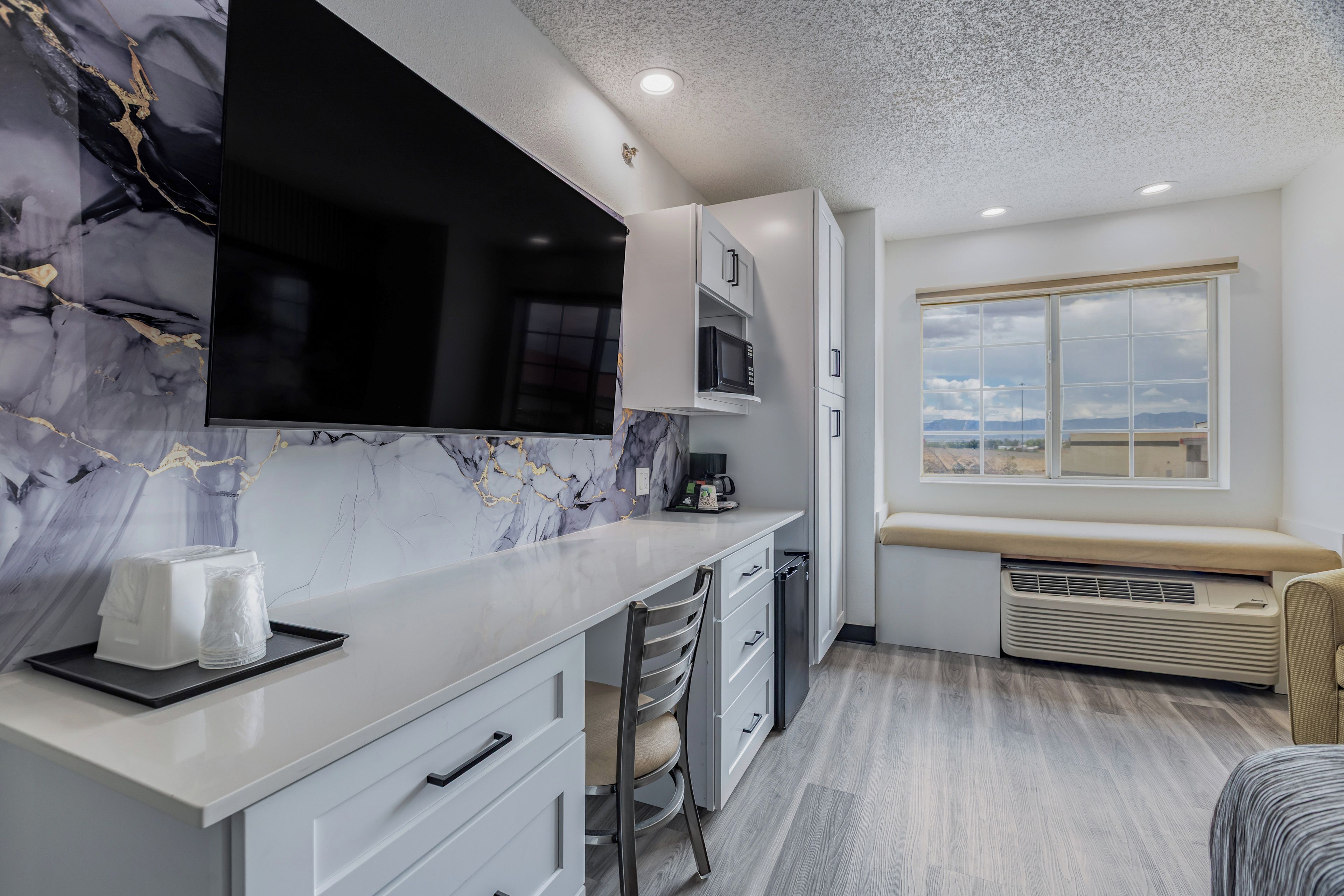 Cozinha moderna com painel de backsplash em mármore, micro-ondas embutido e uma grande janela com vista.