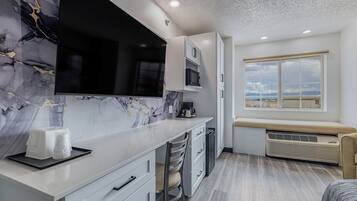Cozinha moderna com painel de backsplash em mármore, micro-ondas embutido e uma grande janela com vista.