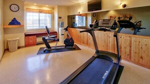 A gym with treadmills, a bench, and a water cooler. - Western Skies Inn And Suites (Los Lunas)