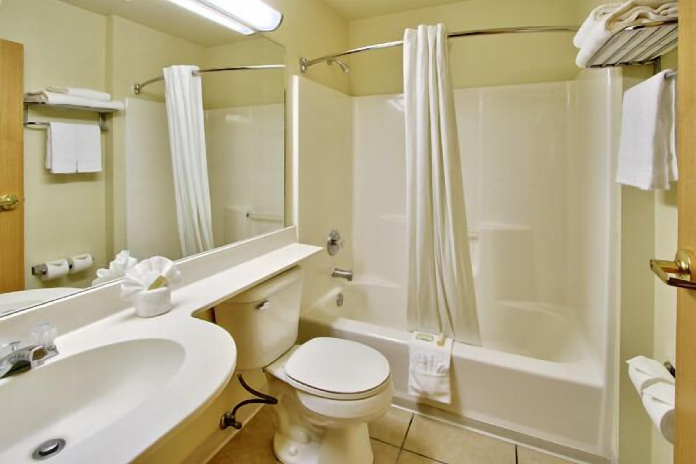 Un baño con lavabo, inodoro, bañera y cortina de ducha.