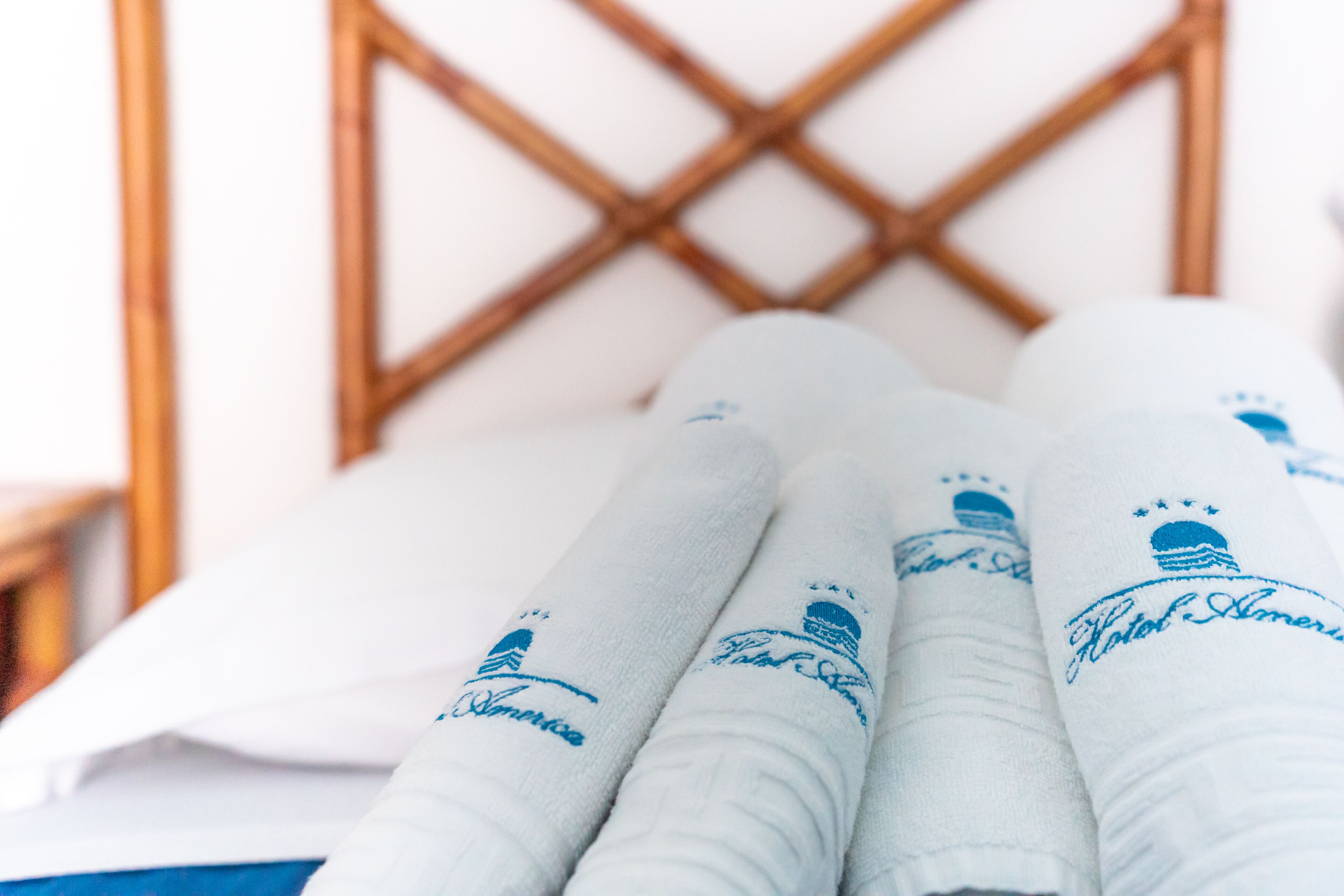 Toallas dobladas con cuidado y texto bordado sobre una cama.