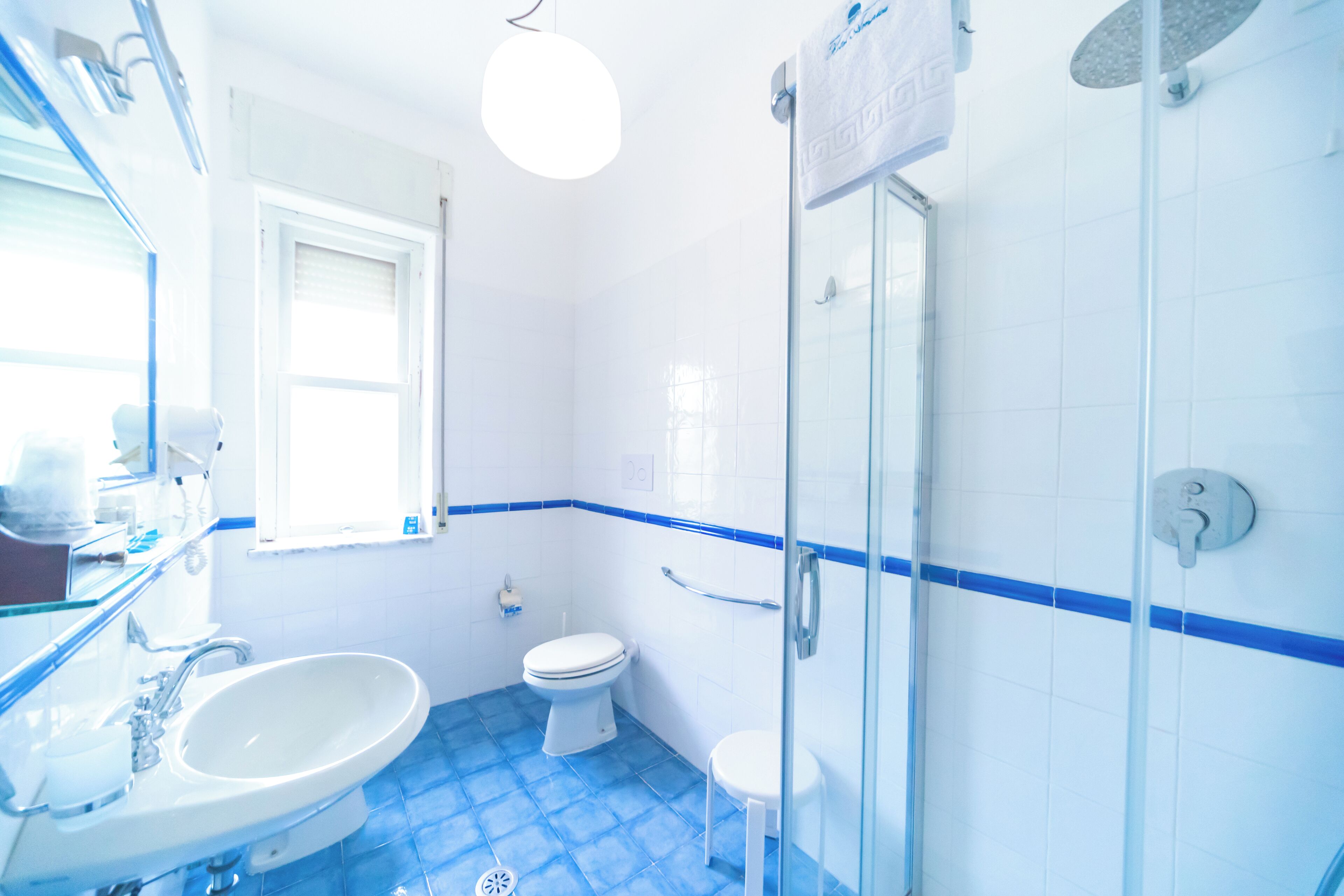 A bathroom with a sink, toilet, and glass shower enclosure.