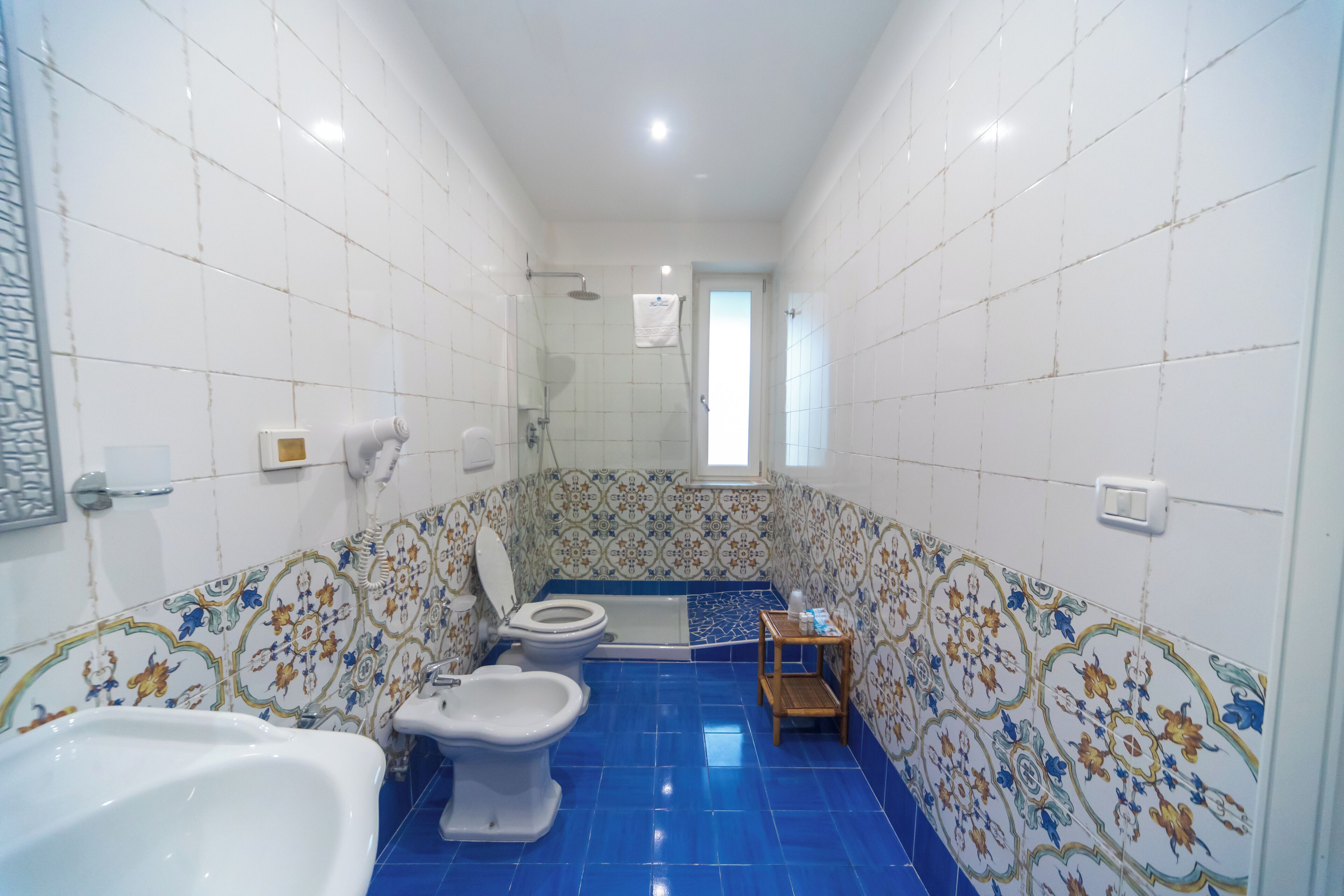 Une salle de bain comprenant des toilettes, un bidet, une baignoire et une douche.
