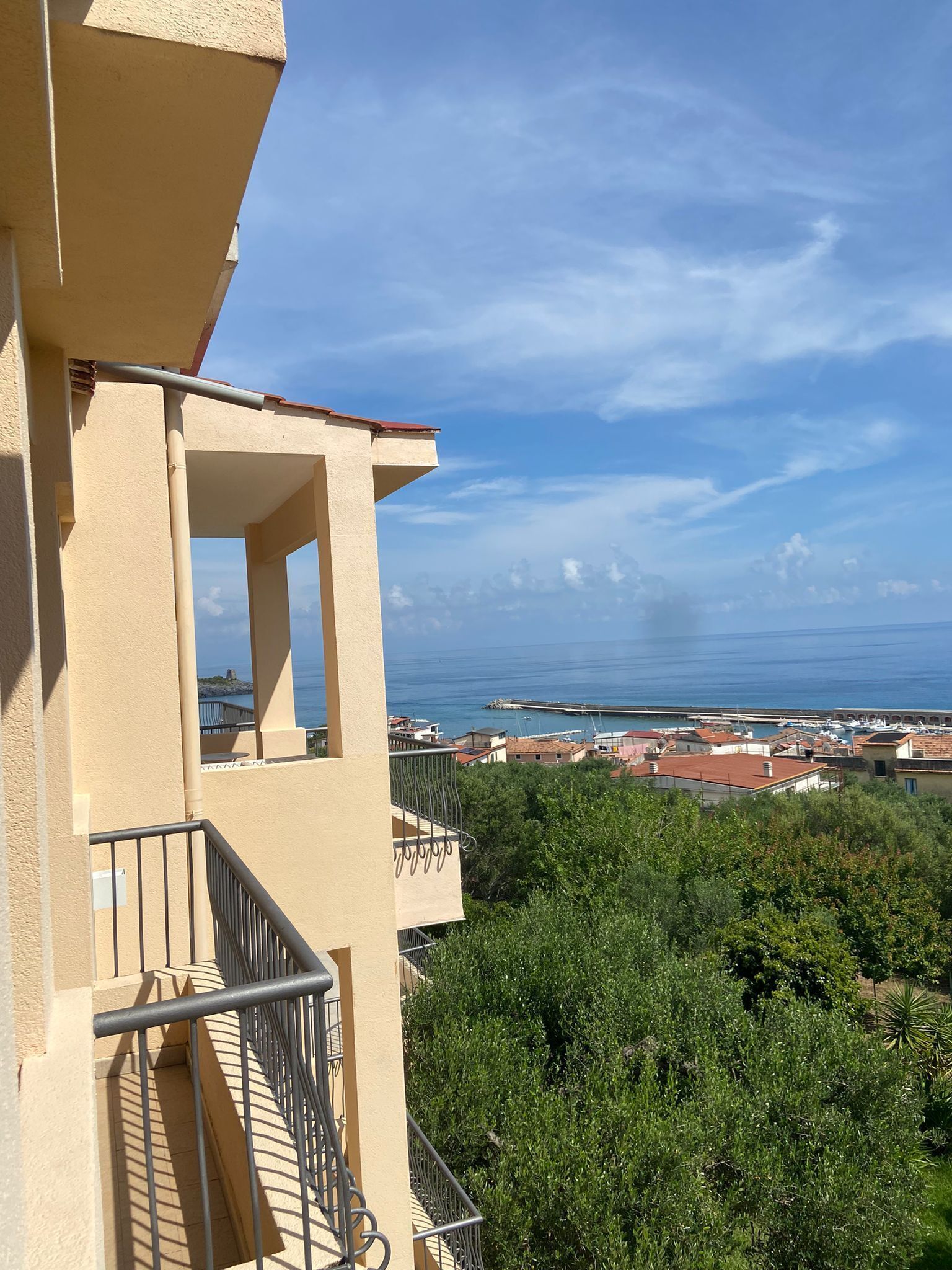 Un balcón con vista al mar y a un pueblo costero.