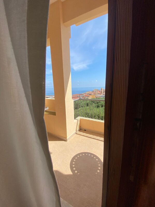 Un balcón con vistas a un pueblo costero y al mar.