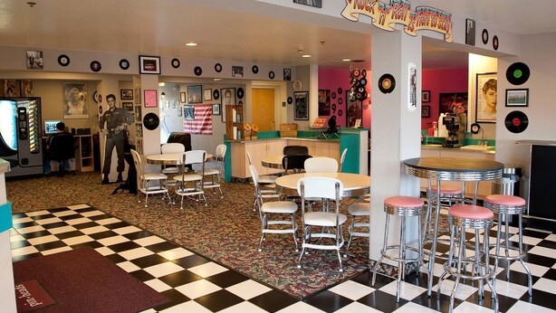 A retro-themed restaurant with checkered flooring, vinyl records on the walls, and a jukebox. - Motel 6 McAlester, OK - South (McAlester)