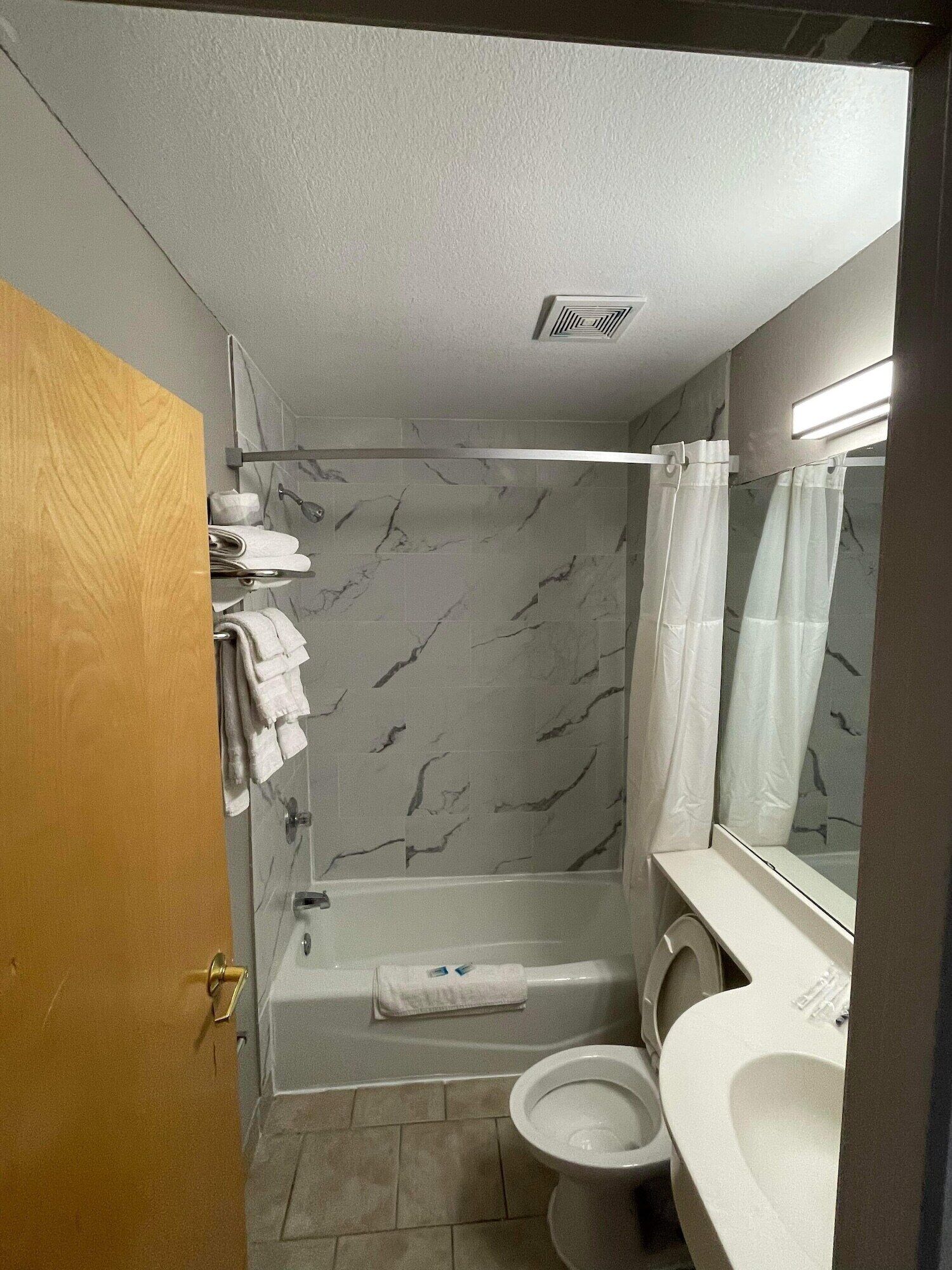 A bathroom with a bathtub, toilet, and sink.
