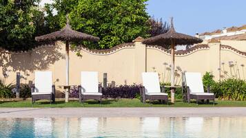 Alberca al aire libre y camastros