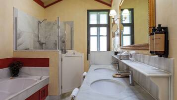 Een badkamer met twee wastafels, een douche en een spiegel.