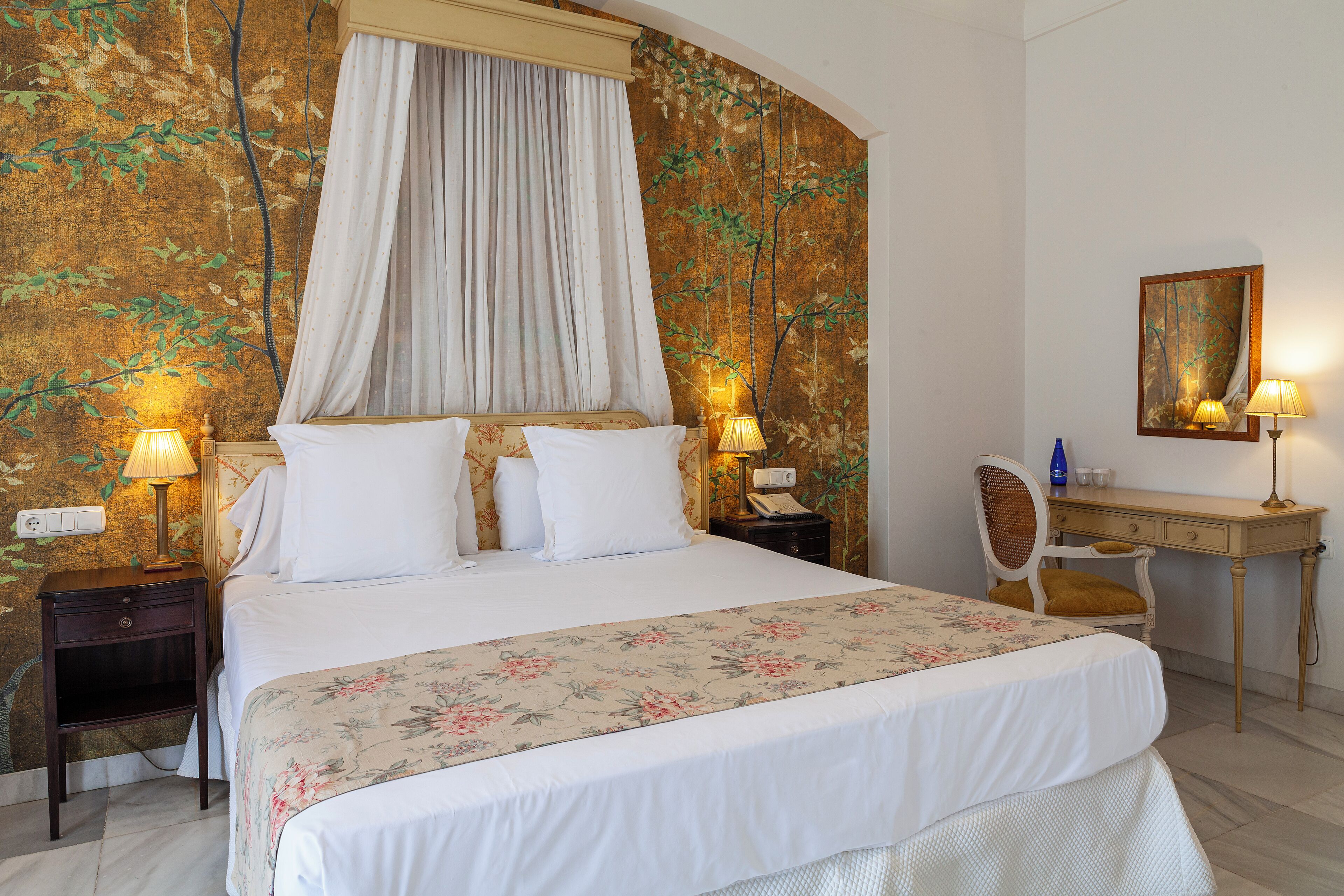 Een keurig opgeruimde hotelkamer met een groot bed, een bureau en een stoel.