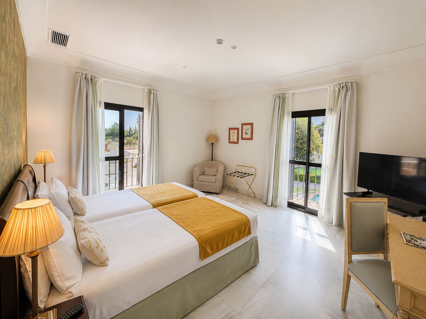 Une chambre d’hôtel avec deux lits, une télévision, un bureau et une chaise.