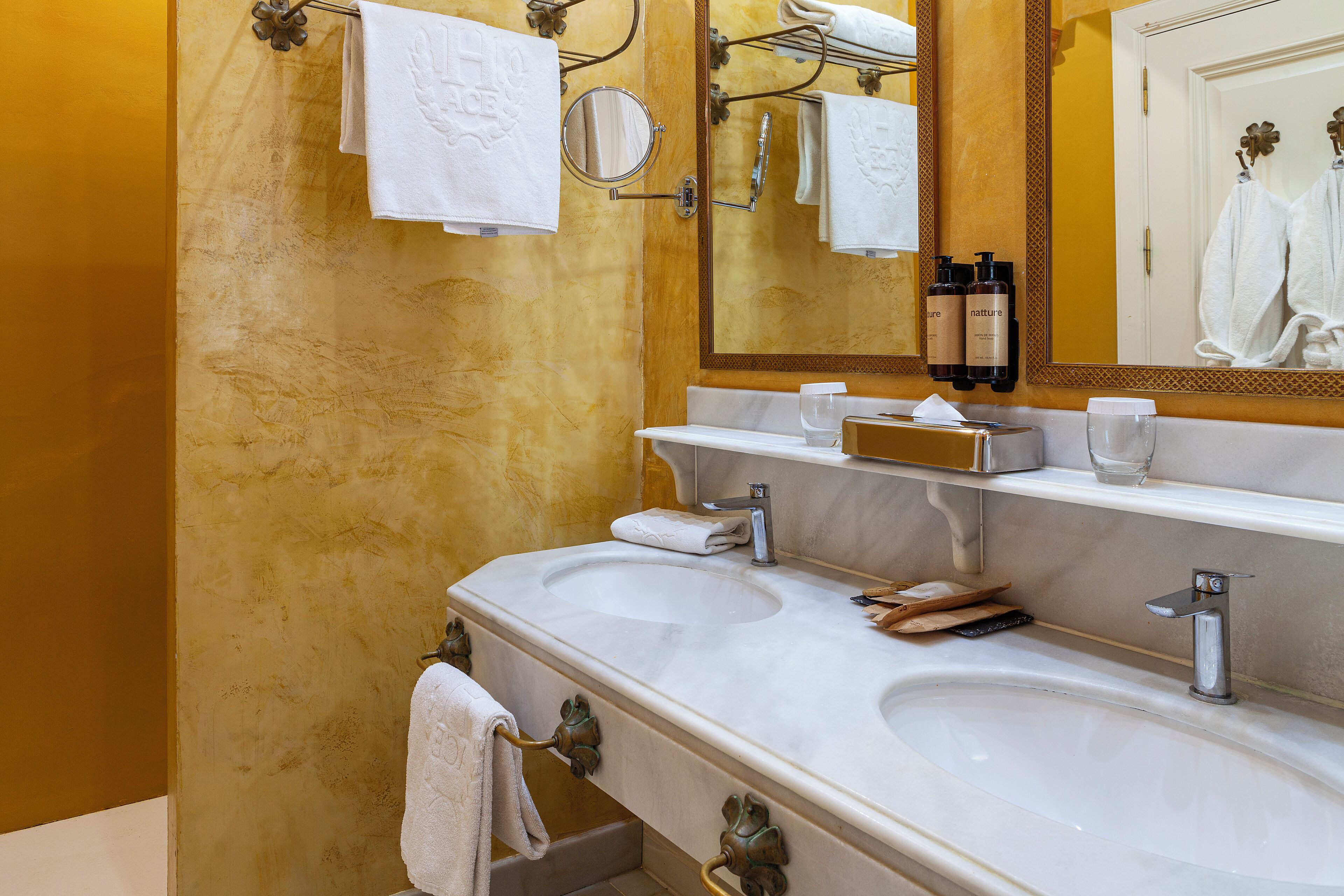 A bathroom with two sinks, a mirror, and a towel rack.