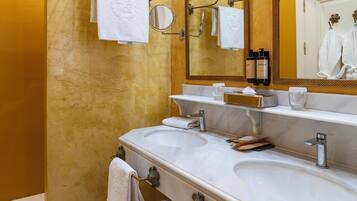 A bathroom with two sinks, a mirror, and a towel rack.