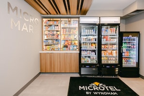 A MicroMart with shelves stocked with snacks and beverages, and two refrigerators. - Microtel Inn & Suites by Wyndham Wellsville (Wellsville)