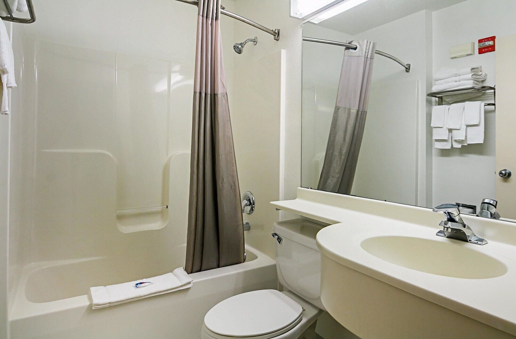 A bathroom with a bathtub, toilet, and sink.