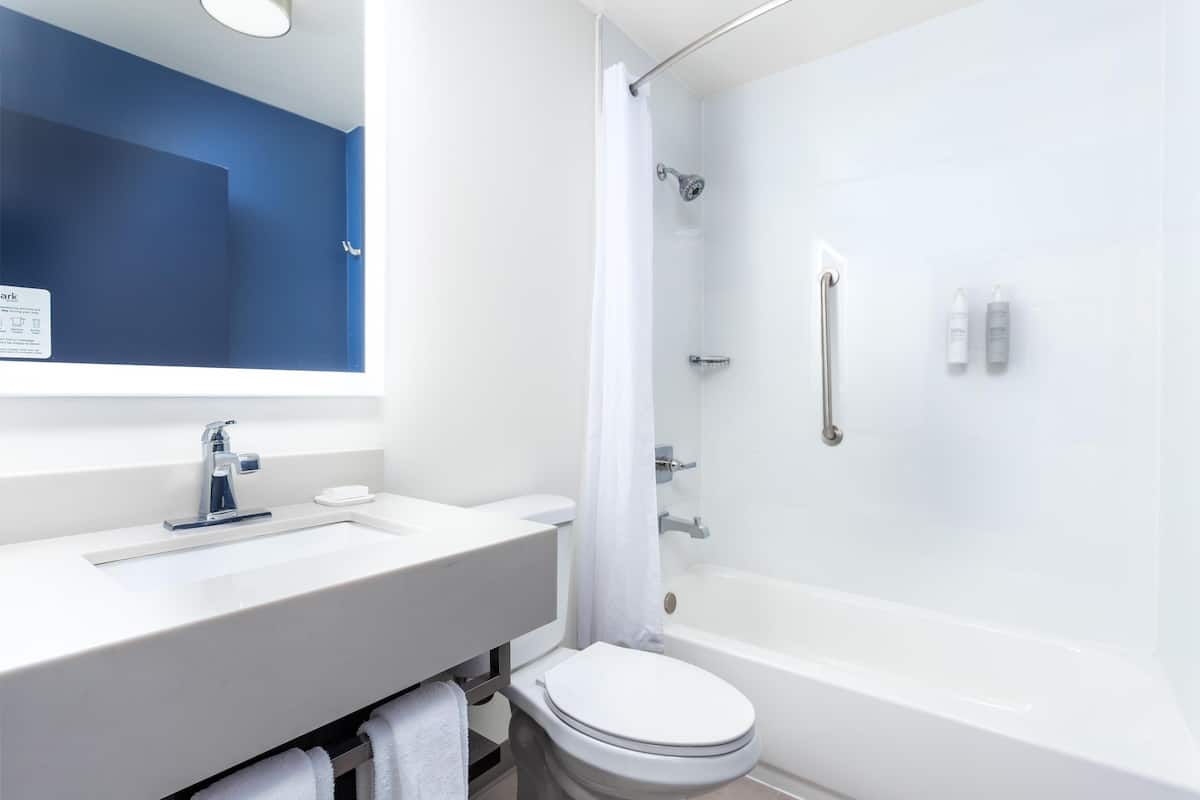 Un baño moderno con lavamanos, inodoro y bañera blancos.