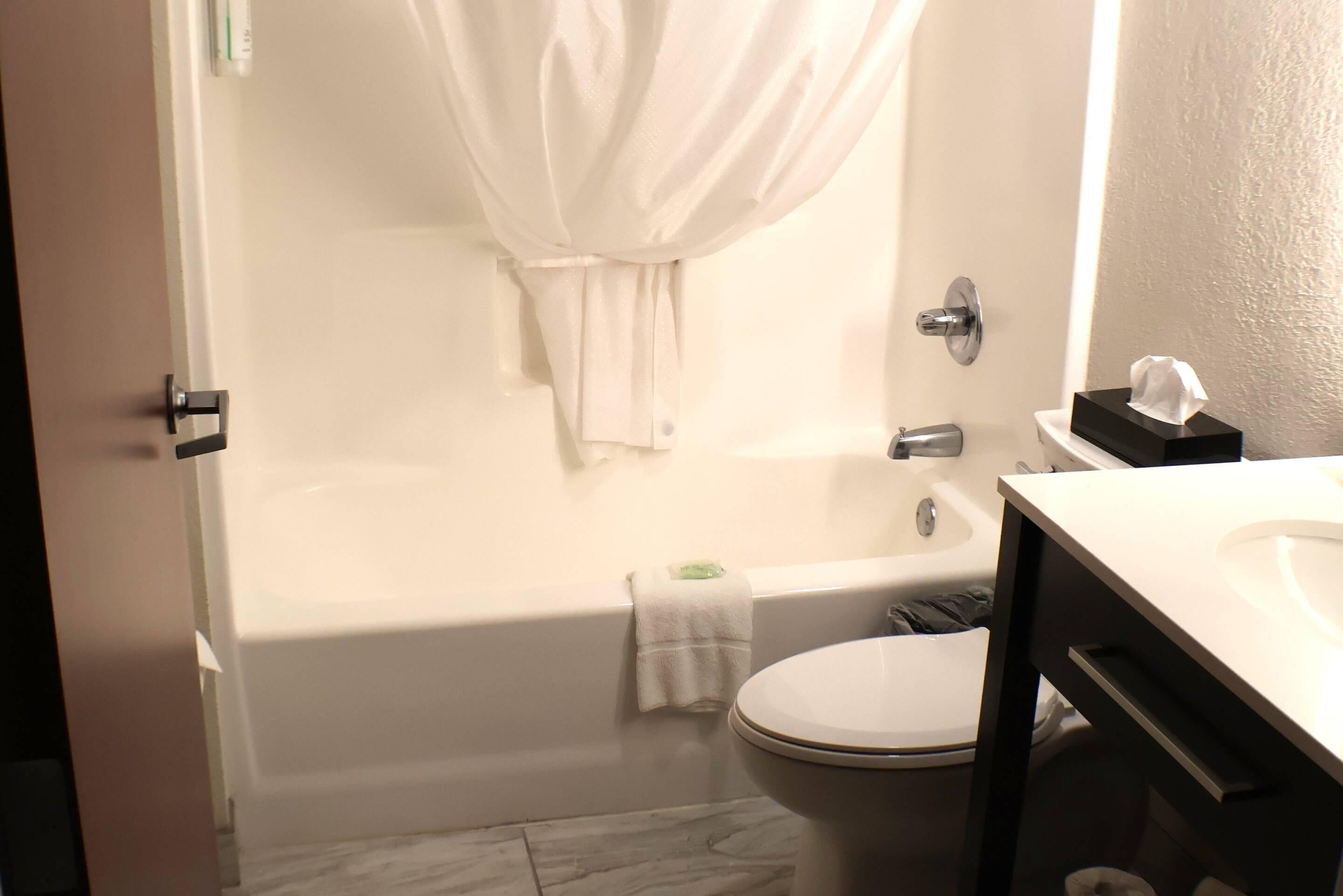 A bathroom with a bathtub, toilet, and sink.