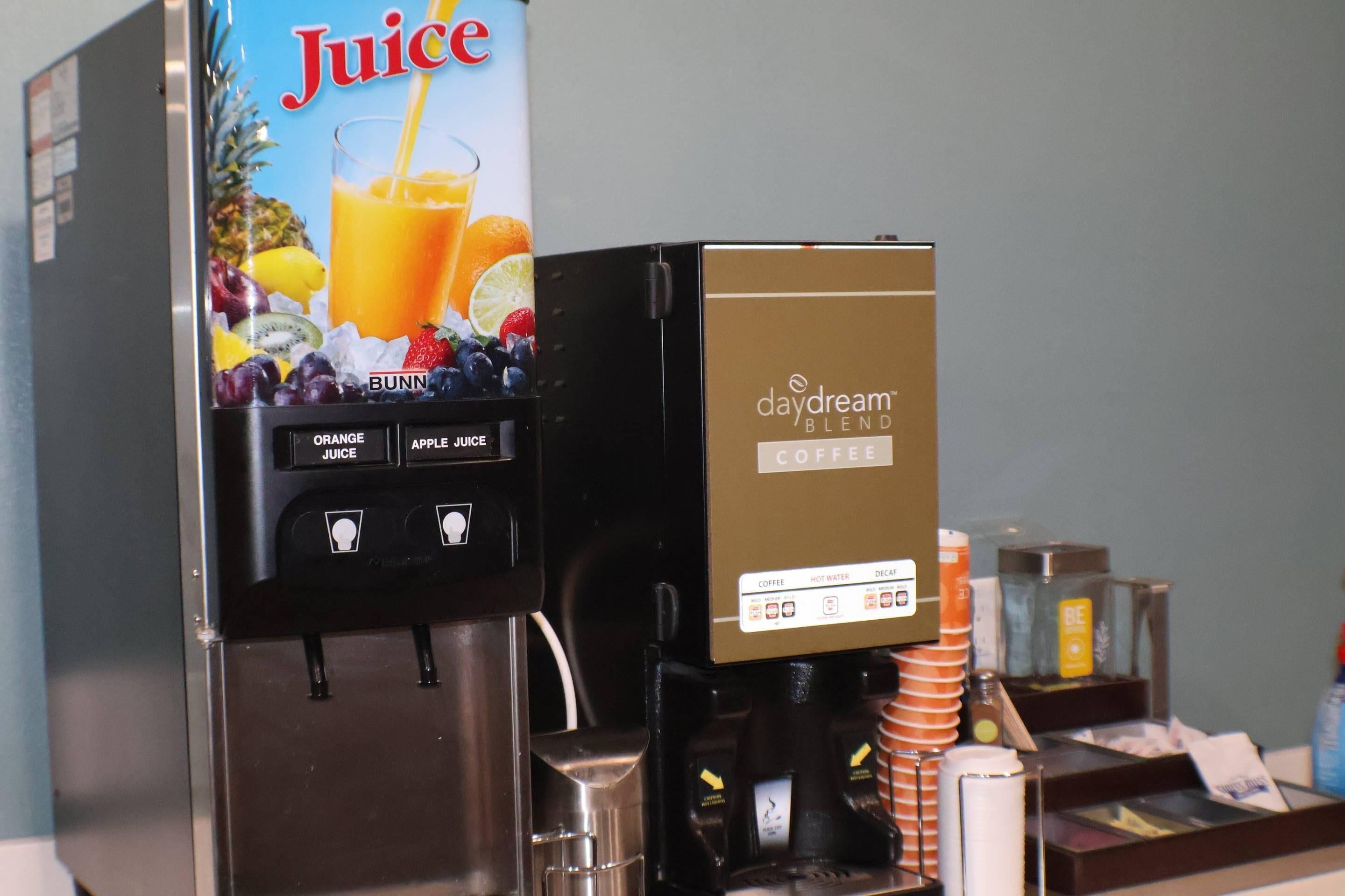 A juice dispenser with options for orange and apple juice, and a coffee machine labeled 'daydream blend coffee.'