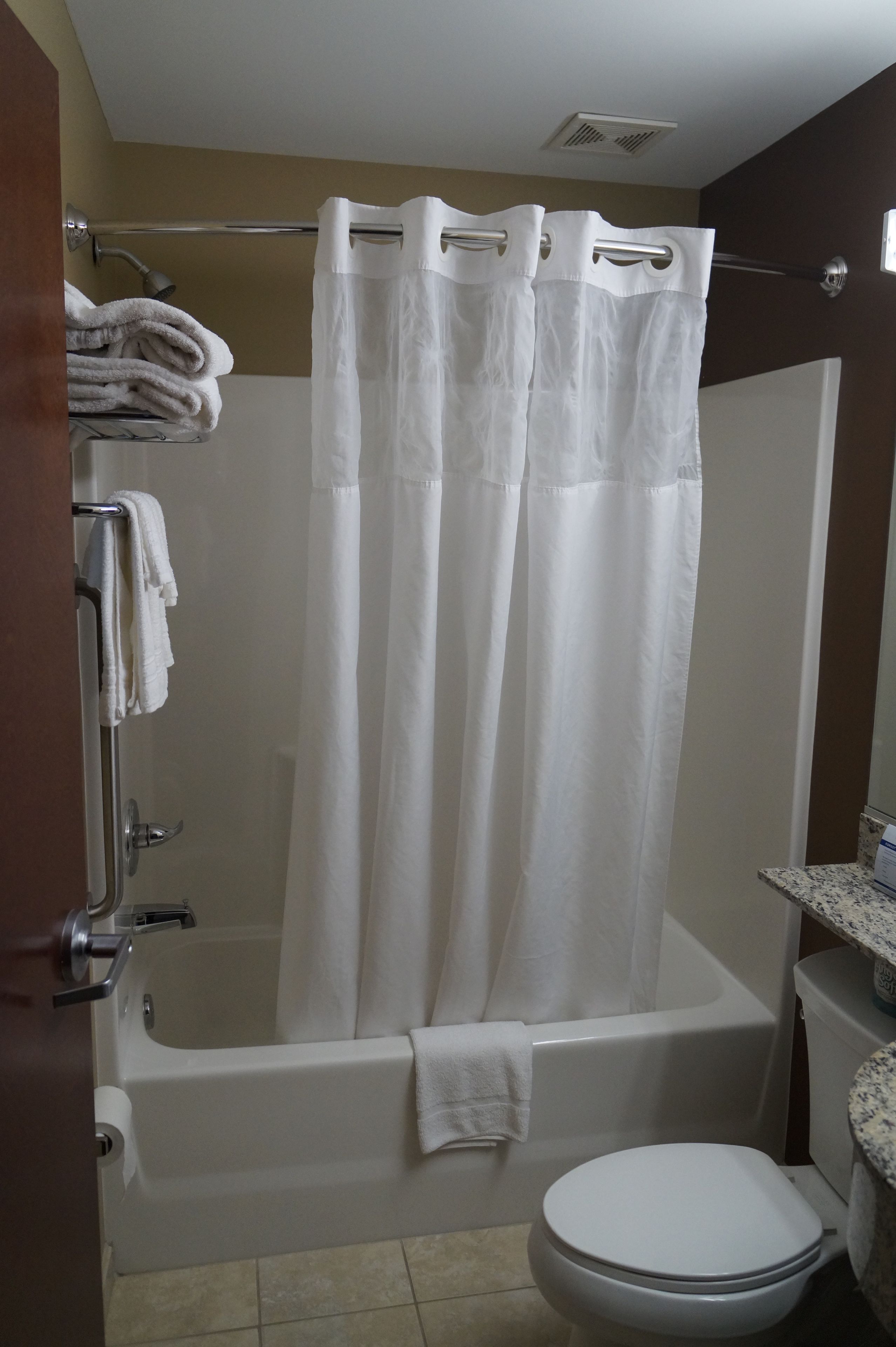 A bathroom with a bathtub, a toilet, and a shower curtain.