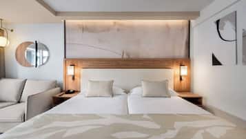 Een moderne hotelkamer met een groot bed, nachtkastjes, een ronde spiegel en abstracte wanddecoratie.