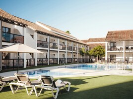 Een buitenzwembad, parasols voor strand/zwembad