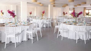 A banquet hall with round tables, white chairs, and floral centerpieces. - Hotel Ona Diana Park (Estepona)