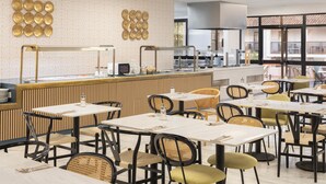 A modern restaurant with a central counter, multiple tables, and chairs. - Hotel Ona Diana Park (Estepona)
