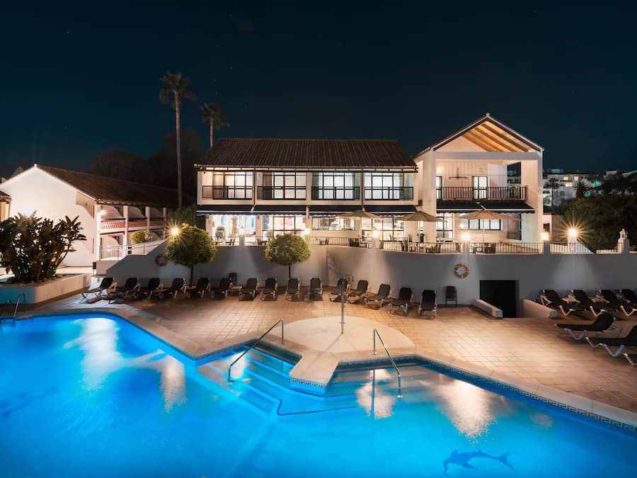 Una piscina al aire libre, sombrillas, tumbonas