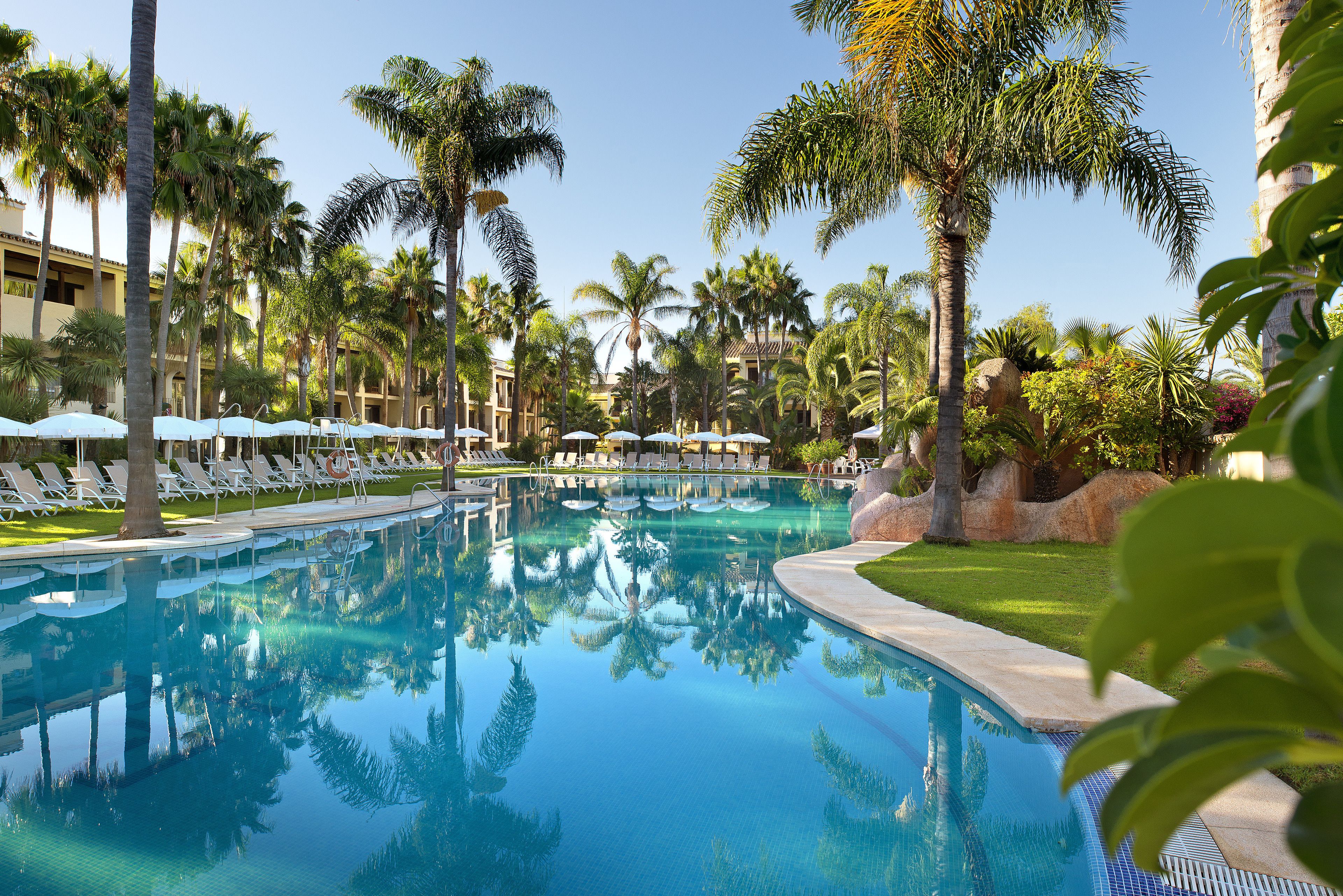 Una piscina al aire libre de temporada, sombrillas