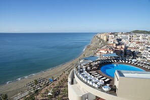 Een buitenzwembad, ligstoelen bij het zwembad