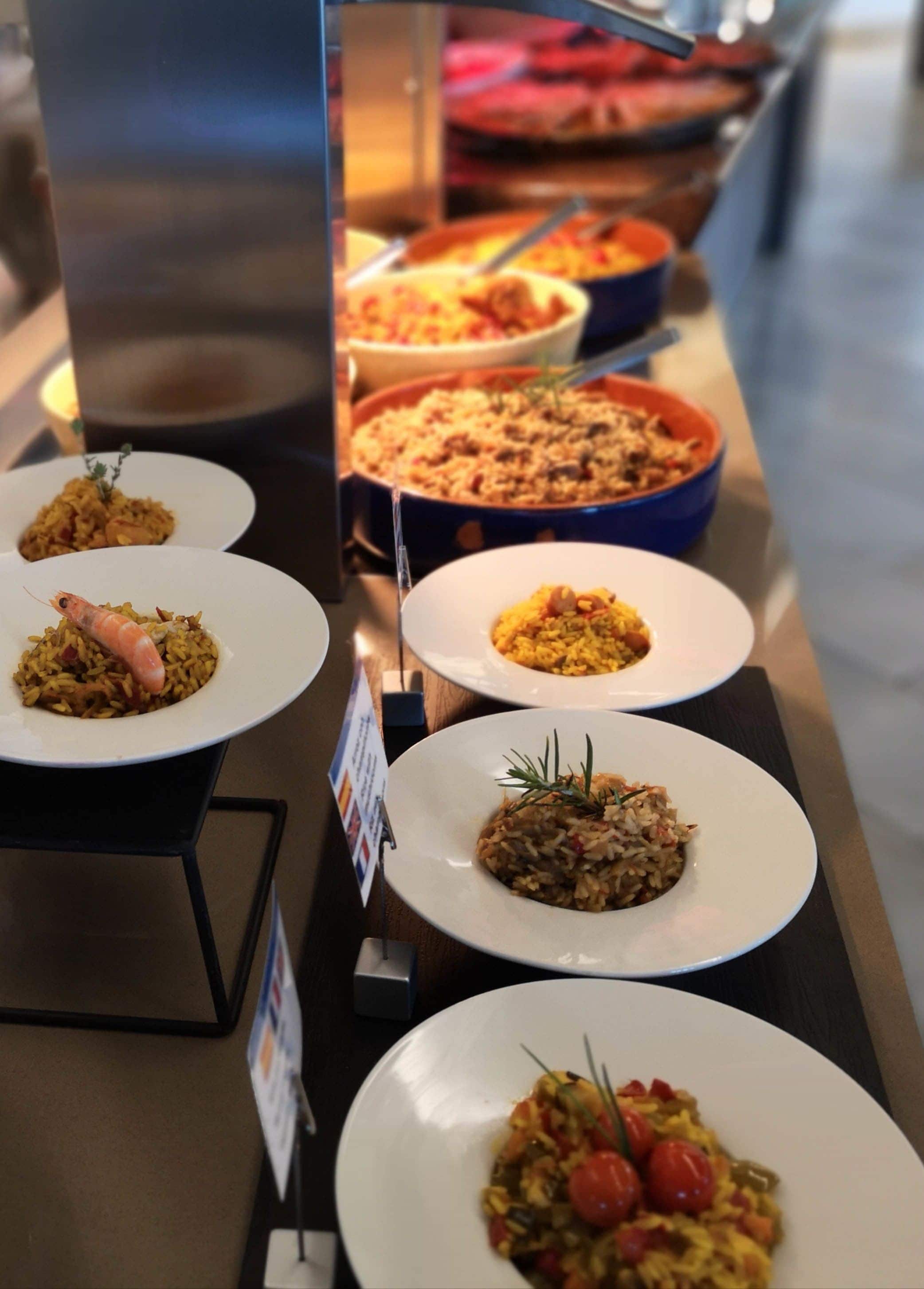 Un bufé con diversos platos, incluyendo arroz y mariscos.