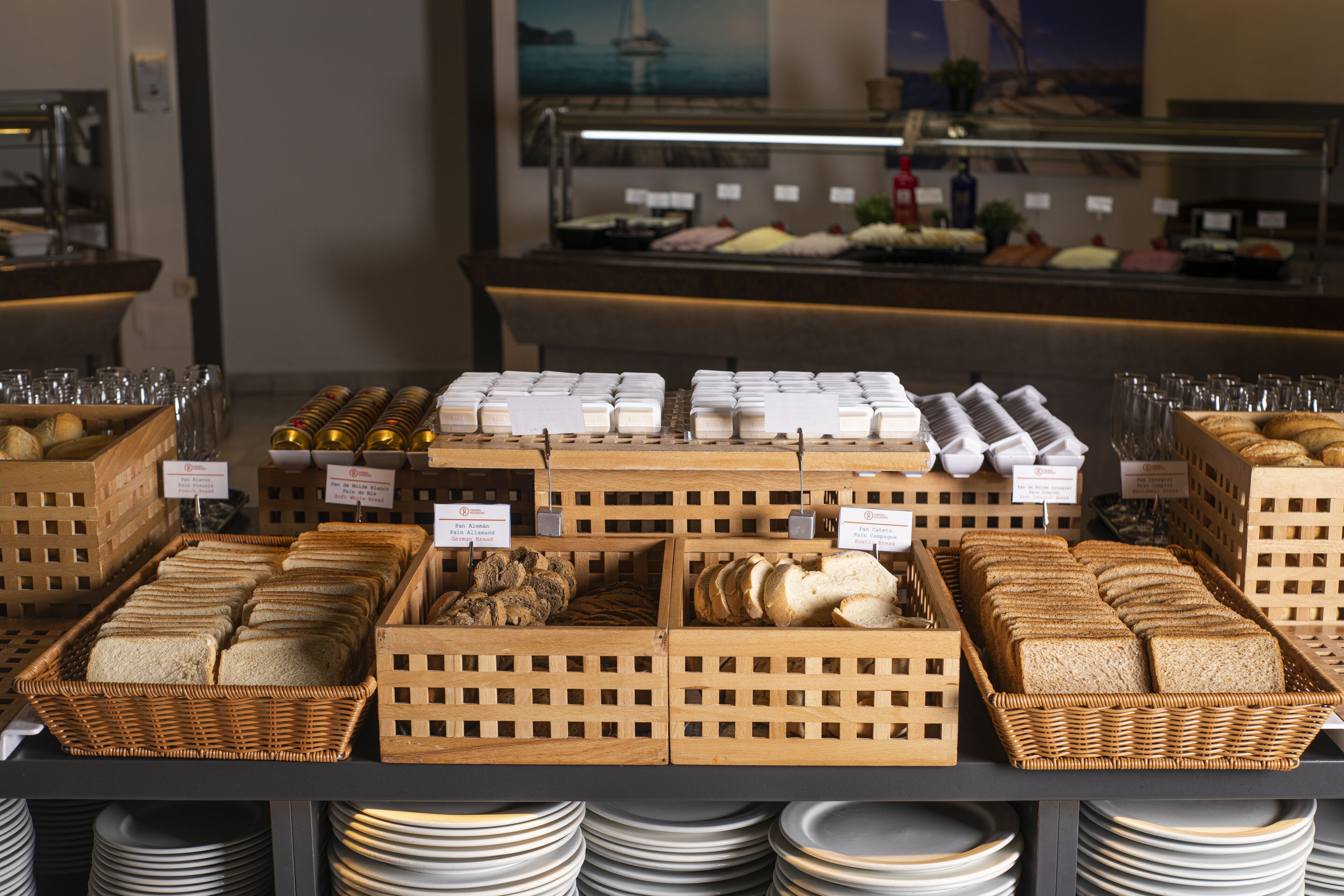A buffet with various breads and pastries displayed in wicker baskets.