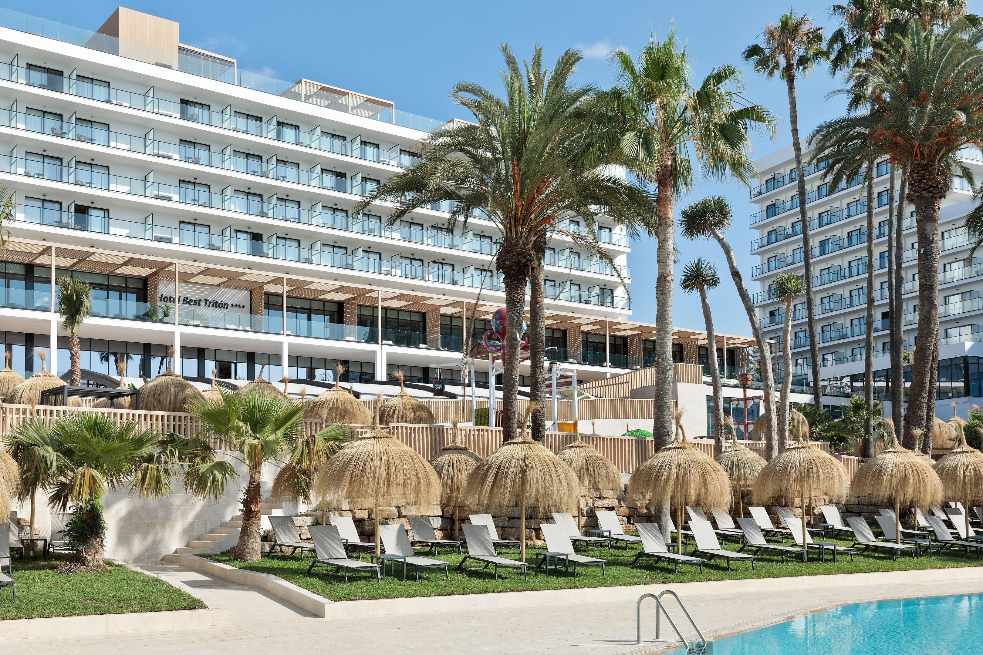 Un hôtel à étages, doté d’une piscine extérieure et de chaises longues.