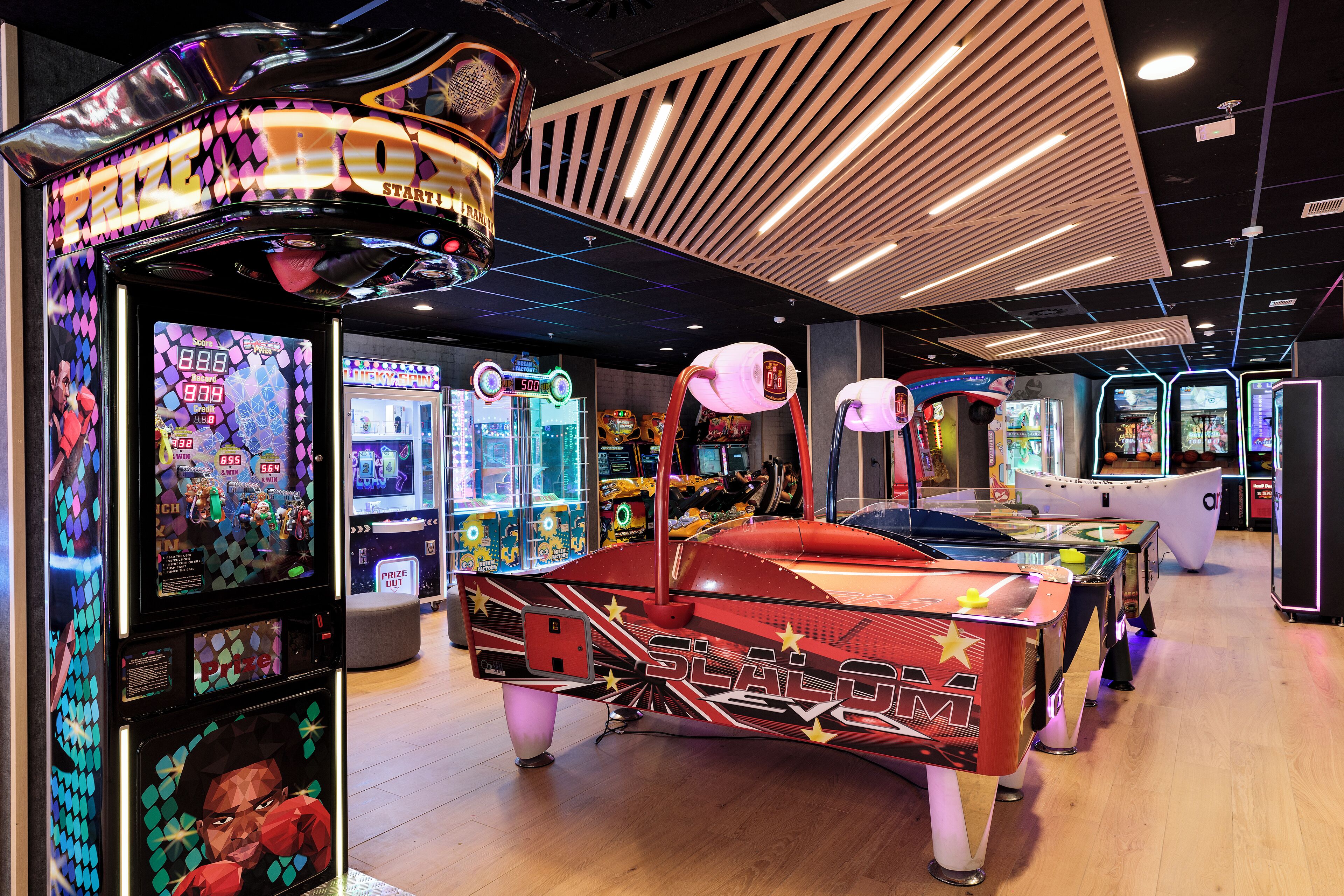 An arcade with various gaming machines, including a prominent 'Slapshot' game.