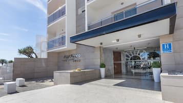 Una entrada de hotel con diseño moderno, que presenta un llamativo cartel que dice 'Best Hotels' y un logotipo 'Best' en la fachada.
