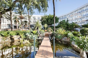A hotel with a pool, surrounded by tropical plants and palm trees. - Hotel Best Siroco (Benalmádena)