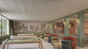 A pool table in a room with green chairs and a sofa, a ceiling with a grid pattern, and a wall with a plant mural. - Hotel Best Siroco (Benalmádena)