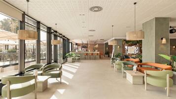 Amplio espacio interior con arreglos de asientos, una mesa de recepción y grandes ventanales que permiten la entrada de luz natural.