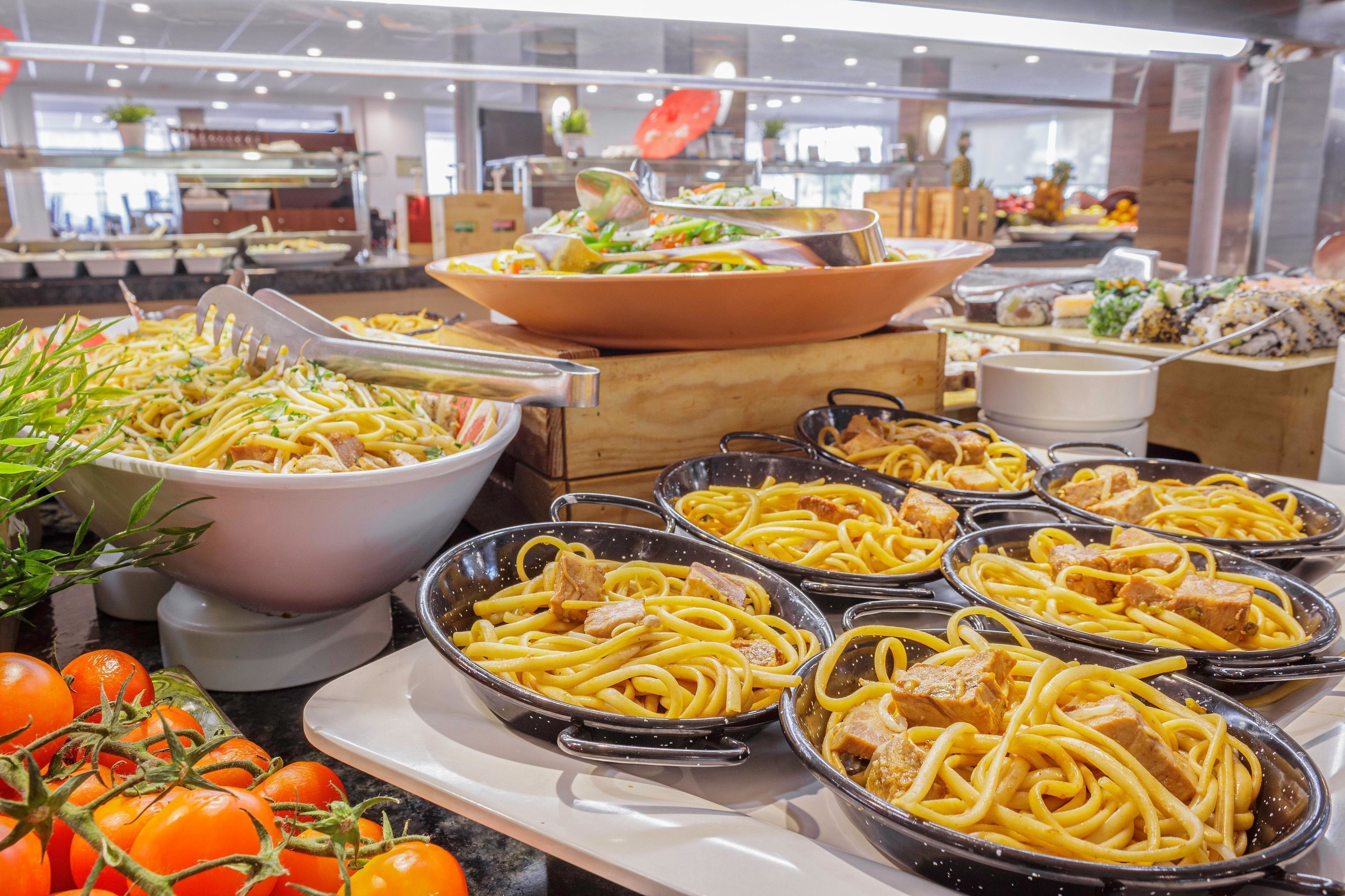 A buffet with various dishes including pasta, salads, and seafood.