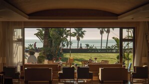 A spacious lobby with a large seating area, a view of the ocean, and a tropical garden. - Hotel MS Amaragua (Torremolinos)