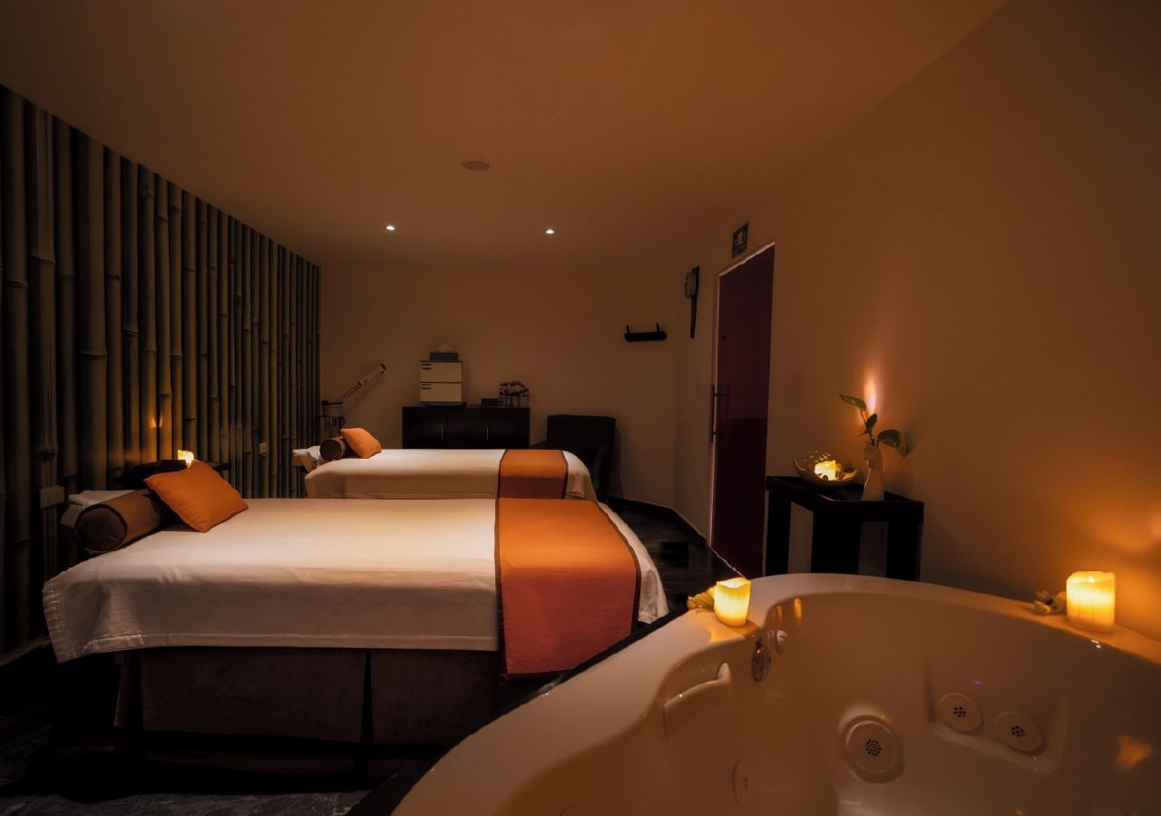 A hotel room with two beds, a large bathtub, and a mirror.