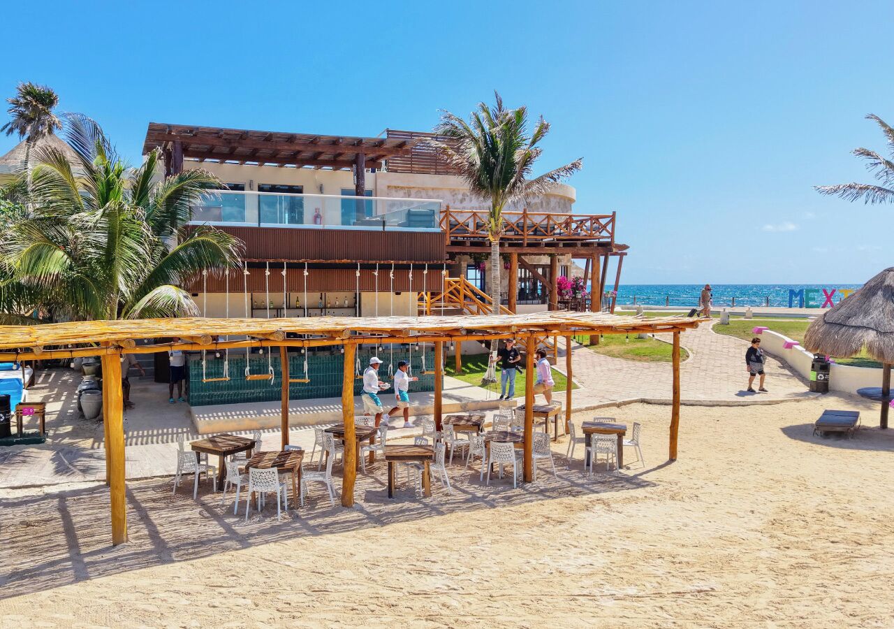 Un restaurante frente a la playa con terraza, piscina y vistas al océano.