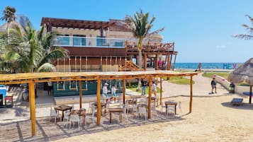 Un restaurante frente a la playa con terraza, piscina y vistas al océano.