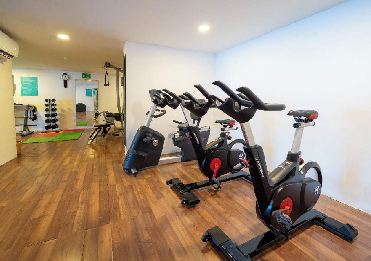 A gym with exercise equipment, including stationary bikes and weights.