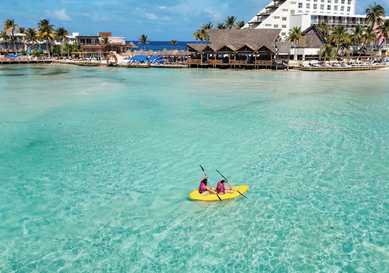 Une mer turquoise aux eaux limpides, avec un kayak au milieu.