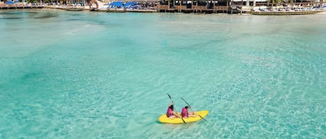 A clear turquoise sea with a kayak in the middle.