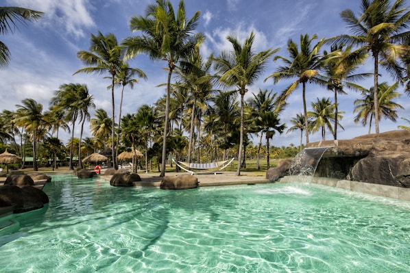 Piscina externa, piscina com cascata, guarda-sóis, espreguiçadeiras