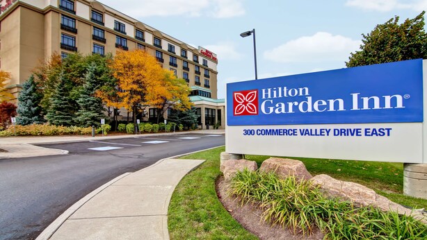 A Hilton Garden Inn sign with a clear view of the building in the background.